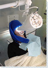 歯に光を照射し、漂白剤を浸透させてる写真