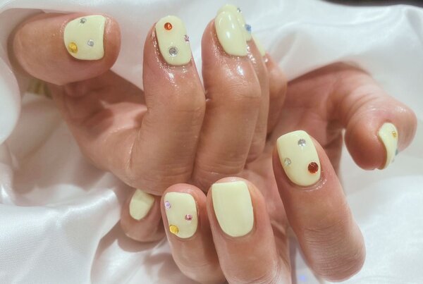 「ハンド 定額デザイン」パステルイエローでパーツはカラフルにバランスを見ながら配置しました！|Nail Salon Linda