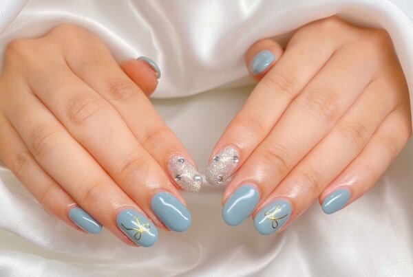 「ハンド 定額デザイン」水色の部分は緑も混ざったような絶妙なカラーでとても可愛いお色味です！ リボンのシールがよく映え！|Nail Salon Linda