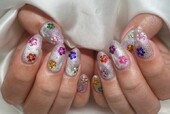 「ハンド ミドルコース」キラキラの上にカラフルなパーツでお花の形にしています|Nail Salon Linda