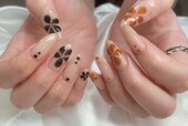 「ハンド ミドルコース」黒のラメとオレンジのラメでお花を描いた可愛らしいデザインです！|Nail Salon Linda