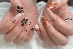 「ハンド ミドルコース」黒のラメとオレンジのラメでお花を描いた可愛らしいデザインです！|Nail Salon Linda