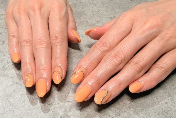 「ハンド 定額デザイン」オレンジのワンカラーにアクセサリーの様なシルバーが可愛いデザインです。|Nail Salon Linda