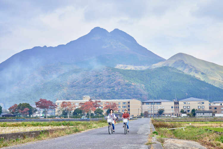 自転車を漕ぐ女性と山の風景