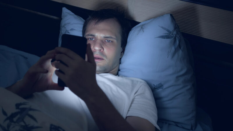 暗闇でスマホを凝視する男性