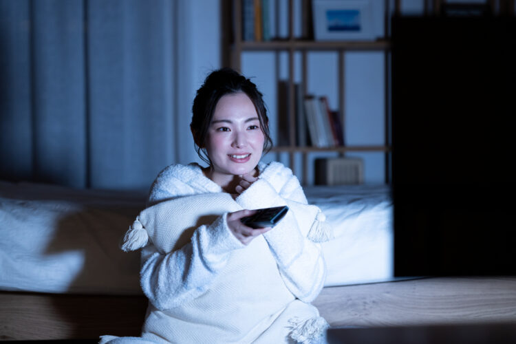 夜テレビを見ている女性のイメージ